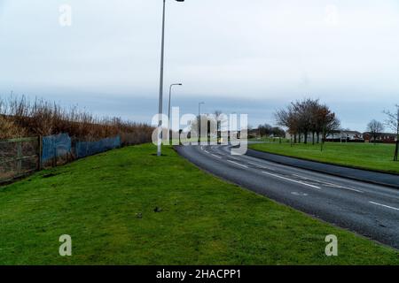 Newhame Rd, Montrose, Angus, Schottland, 12th vom 2021. Dezember: Bild: Die Nachwirkungen eines ernsthaften RTC, bei dem eine Hündin getötet wurde, als ein Auto die Kontrolle über die scharfe Kurve der Newhame Rd verlor, den Straßenbelag aufbog, die Hündin-Geherin schlug und dann in den Bahndamm stürzte. Der tödliche RTC ereignete sich um 8,20pm Uhr am Samstag, dem 11th. Dezember 2021. Gelbe Markierungen auf der Straße stammen von der Polizei und veranschaulichen den Weg, den das Auto eingeschlagen hat. Mitglieder der Öffentlichkeit wurden gesehen, um Blumen in einem Zeichen des Respekts für die Frau zu legen, die starb.Quelle:Barry Nixon/Alamy Live News Stockfoto