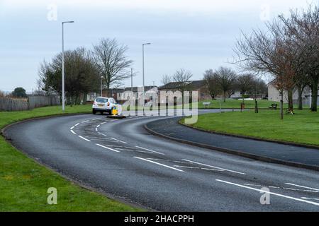 Newhame Rd, Montrose, Angus, Schottland, 12th vom 2021. Dezember: Bild: Die Nachwirkungen eines ernsthaften RTC, bei dem eine Hündin getötet wurde, als ein Auto die Kontrolle über die scharfe Kurve der Newhame Rd verlor, den Straßenbelag aufbog, die Hündin-Geherin schlug und dann in den Bahndamm stürzte. Der tödliche RTC ereignete sich um 8,20pm Uhr am Samstag, dem 11th. Dezember 2021. Gelbe Markierungen auf der Straße stammen von der Polizei und veranschaulichen den Weg, den das Auto eingeschlagen hat. Mitglieder der Öffentlichkeit wurden gesehen, um Blumen in einem Zeichen des Respekts für die Frau zu legen, die starb.Quelle:Barry Nixon/Alamy Live News Stockfoto