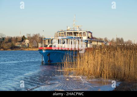 Altes Passagierschiff auf dem eiskalten Fluss Wolkhov an einem sonnigen Dezembermorgen. Staraya Ladoga, Russland Stockfoto