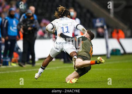 Swansea, Großbritannien. 12th Dez 2021. Sale Sharks-Flügelspieler Marland Yarde wird während des Ospreys gegen Sale Sharks European Champions Cup Rugby Match von Alex Cuthbert, dem rechten Flügel von Ospreys, angegangen. Kredit: Gruffydd Thomas/Alamy Live Nachrichten Stockfoto