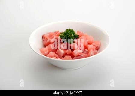 Weiße Schale mit rohem Rinderfleisch in Würfel isoliert auf weißem Hintergrund Stockfoto