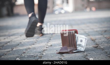 Frau verlor eine Ledertasche mit Geld im Park. Stockfoto