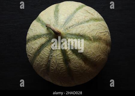 Fotografie einer Melone von Charentais auf Schieferhintergrund für Lebensmittelillustrationen Stockfoto