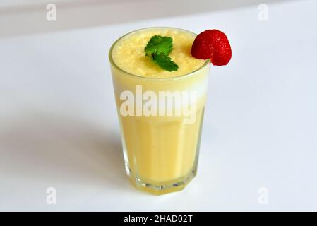 Gesunde gelbe Smoothie mit Stroh in einem Glas Becher isoliert auf weißem Stockfoto
