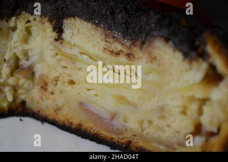 Texturierte Nahaufnahme auf einem Stück Schokoladenapfelkuchen auf einem weißen Porzellanteller. Weihnachtsbonbons. Stockfoto