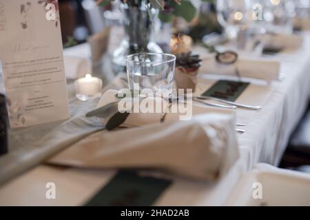 Wunderschön angeordetes Geschirr und Namensschilder mit den Namen der Gäste auf dem Tisch bei der Hochzeit Stockfoto