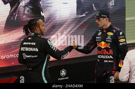 12. Dezember 2021, Vereinigte Arabische Emirate, Abu Dhabi: Motorsport: Formel-1-Weltmeisterschaft, Abu Dhabi Grand Prix, Rennen. Lewis Hamilton (l) aus Großbritannien vom Team Mercedes gratuliert dem Niederländer Max Verstappen vom Team Red Bull zum Weltmeistertitel. Verstappen hat zum ersten Mal den Formel-1-Fahrertitel geholt und damit Rekordweltmeister Hamilton entthront. Foto: Hasan Bratic/dpa Stockfoto