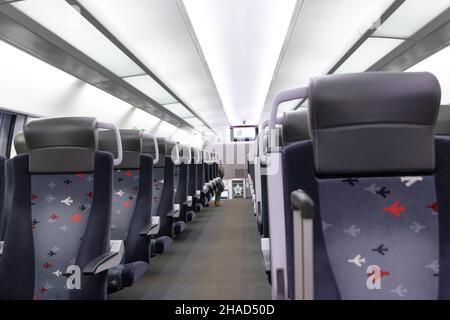 Eine leere Kabine des aeroexpress-Zuges ohne Passagiere. Weiche Sitze in einer Reihe mit Kopfstützen aus Leder. Öffentlicher Ort. Selektiver Fokus. Nahaufnahme Stockfoto