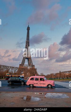 Lustiges rosafarbenes Auto Marc Jacobs parkte in Paris mit Eiffelturm im Hintergrund. Stockfoto