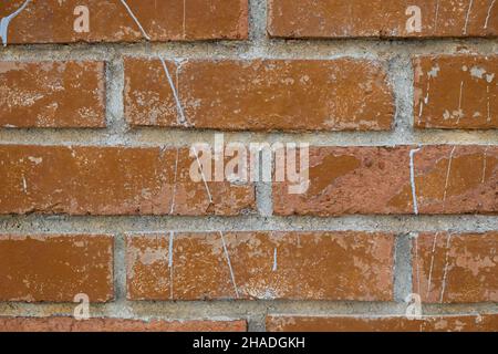 Struktur der Ziegelwände. Hellbraune rechteckige Ziegel in Nahaufnahme, mit Farben besprüht. Abstrakte Konstruktion Haar Hintergrund. Außenansicht einer Wand oder fenc Stockfoto