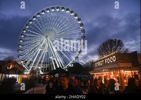 Brighton UK 12th December 2021 - Besucher genießen das Brighton Christmas Festival und erleben das Leben im Old Steine mit einem großen Beobachtungsrad im Zentrum der festlichen Attraktion : Credit Simon Dack / Alamy Live News Stockfoto