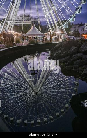 Brighton UK 12th December 2021 - Besucher genießen das Brighton Christmas Festival und erleben das Leben im Old Steine mit einem großen Beobachtungsrad im Zentrum der festlichen Attraktion : Credit Simon Dack / Alamy Live News Stockfoto