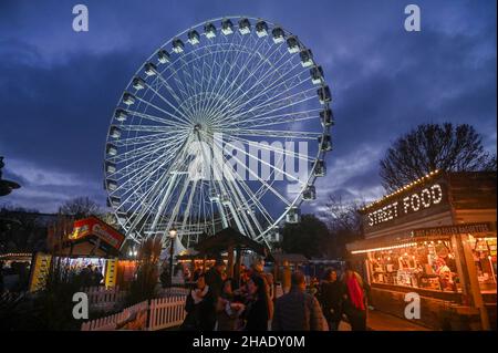 Brighton UK 12th December 2021 - Besucher genießen das Brighton Christmas Festival und erleben das Leben im Old Steine mit einem großen Beobachtungsrad im Zentrum der festlichen Attraktion : Credit Simon Dack / Alamy Live News Stockfoto