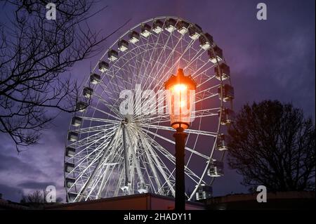 Brighton UK 12th December 2021 - Besucher genießen das Brighton Christmas Festival und erleben das Leben im Old Steine mit einem großen Beobachtungsrad im Zentrum der festlichen Attraktion : Credit Simon Dack / Alamy Live News Stockfoto