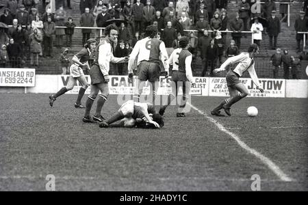 1973, historisch, ein Fußballspiel im Valley, South-East London, England, Großbritannien, Heimat des Charlton Athletic FC. In einem Spiel gegen Blackburn wird ein Spieler nach einem Angriff am Boden verletzt, aber das Spiel geht weiter. Fans oder Unterstützer stehen auf den Terrassen, einige hinter einer Stahlbarriere, und beobachten das Spiel. Charlton Athletic FC wurde 1905 gegründet und spielt seit 1919 im Valley. Stockfoto