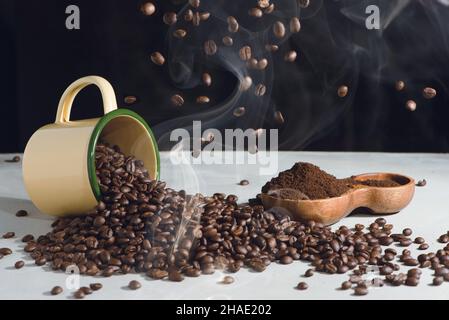 Kaffeetasse und Bohnen verteilen und gemahlen in einer Holzschüssel auf weißem Hintergrund Stockfoto