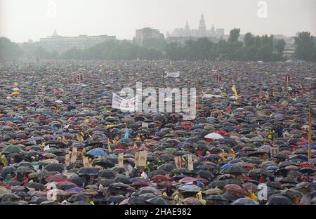 Kraków 15.06.1999. VII pielgrzymka Papier¿a Jana Paw³a II do Polski. Msza œw. na krakowskich B³oniach promebrowana przez sekretarza stanu Stolicy Apostolskiej, kardyna³a Angelo Sodano. Przed jej rozpoczêciem BP Kazimierz Nycz oznajmi³, ¿e Papier¿ jest przeziêbiony i nie przybêdzie na B³onia. Nz. 1,5 mln wernych w strugach deszczu. mw PAP/Grzegorz Jakubowski Krakau, Den 15. Juni 1999. Die siebte Pilgerreise von Papst Johannes Paul II. Nach Polen. Im Bild: 1,5 Millionen Gläubige nehmen bei strömendem Regen an einer Messe auf Blonie Common Teil. Die Messe wird vom Vatikan-Staatssekretär Kardinal Angelo Sodano, dem Papst, gefeiert Stockfoto