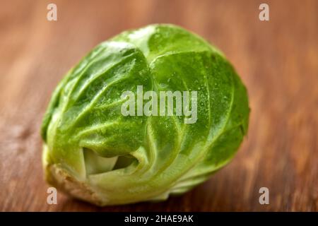 Nahaufnahme eines frischen rohen grünen rosenkohlers auf Holz Stockfoto