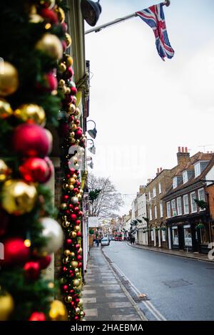 Eton, Großbritannien. 12th. Dezember 2021. Weihnachtsdekorationen sind in der Eton High Street abgebildet. Laut dem Office of National Statistics (ONS) geben britische Haushalte mehr für Waren und weniger für Dienstleistungen aus, während sich die Omicron-Coronavirus-Variante ausbreitet. Kredit: Mark Kerrison/Alamy Live Nachrichten Stockfoto