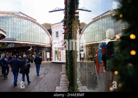 Windsor, Großbritannien. 12th. Dezember 2021. Die Menschen kommen an einem weihnachtlichen Schaufenster im Stadtzentrum vorbei. Laut dem Office of National Statistics (ONS) geben britische Haushalte mehr für Waren und weniger für Dienstleistungen aus, während sich die Omicron-Coronavirus-Variante ausbreitet. Kredit: Mark Kerrison/Alamy Live Nachrichten Stockfoto