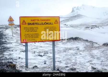 Winteransicht bei schlechtem Wetter auf den Berg Hreggnasi auf der Halbinsel Snæfellsnesnes im westlichen Teil Islands mit Warnschildern showi Stockfoto