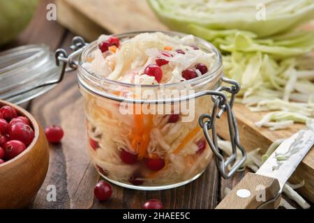 Krug mit saurem Kohl, eingelegtem Sauerkraut. Fermentierter Kohl mit Preiselbeeren, Krautsalat. Gesunde Ernährung, Diät-Lebensmittel. Stockfoto