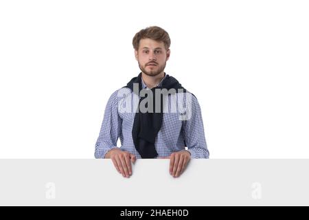 Junge stilvolle Casual Business Mann hinter einem leeren Schild Banner isoliert auf weißem Hintergrund Stockfoto