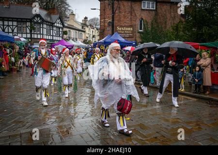 Lymm, KH, Großbritannien. Samstag, 11. Dezember 2021 – Lymm, Hémieh, England, Vereinigtes Königreich. Das jährliche Lymm Dickensian Christmas Festival in Lymm Village kehrt nach einer Pause aufgrund von COVID 19 zurück. Eine Reihe von Ständen und Händlern, die eine Vielzahl von Kunsthandwerk und Weihnachtsgeschenken verkaufen, sowie eine große Auswahl an Speisen, säumen die Dorfstraßen mit Dickenser-Charakteren in Hülle und Fülle. Es gibt auch einen Santa Dash und eine Grand Parade. Die Tänzer des Earl of Stamford Morris unterhielten den ganzen Tag über, aber einige trugen eine Plastikhülle Stockfoto