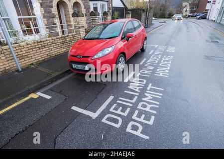 Parkbereich nur für Inhaber von Genehmigungen in der Straße mit zweisprachigem Englisch und Walisisch, Abergavenny, Wales, Großbritannien Stockfoto