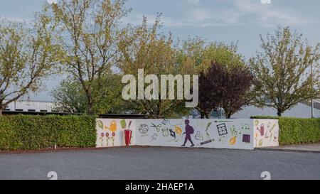 Eingang zu einer Schule mit Symbolen der Bildung, die die Kinder Unternehmen werden, gemalt auf eine Wand in hellen Farben Stockfoto