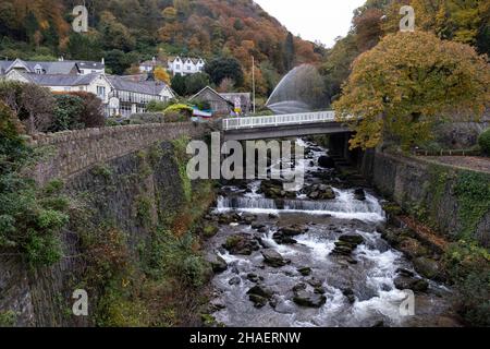 Auf der Glen Lyn Gorge Power of Water Ausstellung am 11th. November 2021 in Lynmouth, Großbritannien, sprüht Wasser in die Luft. Lynmouth ist ein Dorf am nördlichen Rand von Exmoor. Das Dorf erstreckt sich über den Zusammenfluss der Flüsse West Lyn und Ost Lyn, in einer Schlucht 700 Fuß 210 m unterhalb von Lynton. Der South West Coast Path und der Tarka Trail führen durch Lynmouth, das berühmt wurde, als eine verheerende Flut auf einen starken Sturm folgte, der das Dorf am Boden verwüstete. Über Nacht wurden über 100 Gebäude zerstört oder schwer beschädigt, zusammen mit 28 der 31 Brücken. Insgesamt starben 34 Menschen. Stockfoto