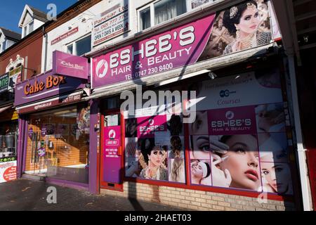 Friseursalon und Schönheitssalon an der Stratford Road in Sparkhill, einem innerstädtischen Viertel von Birmingham, gelegen zwischen Springfield, Hall Green und Sparkbrook, am 25th. November 2021 in Birmingham, Großbritannien. Der Sparkhill wurde stark von Migranten beeinflusst, die sich über viele Jahrzehnte hier niedergelassen haben. Es hat eine große Bevölkerung ethnischer Minderheiten, hauptsächlich südasiatischer Herkunft, was sich in der Anzahl asiatischer Restaurants in der Region widerspiegelt. Als Ergebnis hat sich Sparkhill zu einem Hauptzentrum im Balti-Dreieck von Birmingham entwickelt. Stockfoto