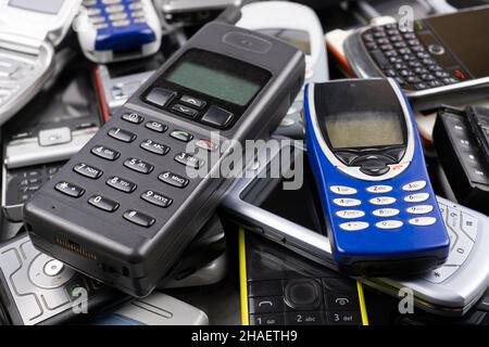 Ein Heap von alten gebrauchten Handys mit Tastatur. Gespeicherte persönliche Daten in einer Menge von Kommunikationsgeräten Konzept Stockfoto