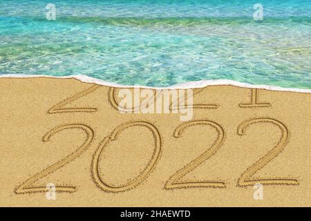 Frohes neues Jahr 2022 und verlassen Jahr 2021 Konzept Text am Strand Stockfoto