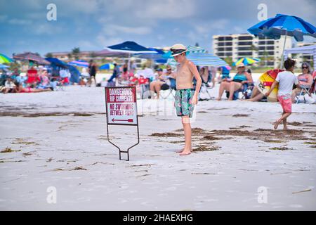 06. Mai 2021: Ein männliches Kind schaut auf das Warnschild der Rip-Strömungen am Siesta Beach in der US-amerikanischen Bundesstaat Florida Stockfoto