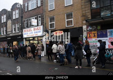 London, Großbritannien. 12th Dez 2021. Menschenmassen in der Brick Lane. Warteschlange bei Beigel Bake.Quelle: JOHNNY ARMSTEAD/Alamy Live News Stockfoto