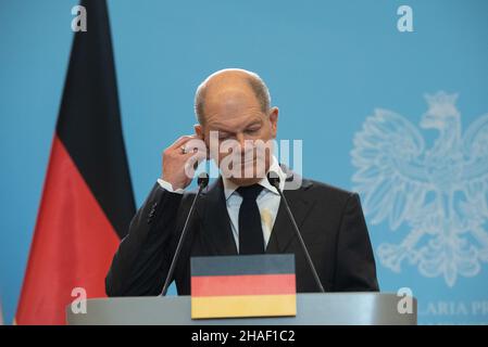 Warschau, Warschau, Polen. 12th Dez 2021. Bundeskanzler Olaf Scholz passt bei einer Pressekonferenz im Kanzleramt des Premierministers am 12. Dezember 2021 in Warschau, Polen, seinen Kopfhörer an. Der neu vereidigte deutsche Bundeskanzler Olaf Scholz besuchte Warschau zum ersten Mal als Kanzler, um mit dem polnischen Ministerpräsidenten Mateusz Morawiecki unter anderem über EU-Angelegenheiten, Migrationskrise und Energiepolitik zu diskutieren. (Bild: © Aleksander Kalka/ZUMA Press Wire) Stockfoto