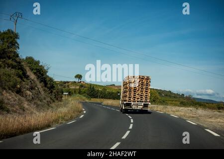 Überlastete LKW mit Altholzpaletten hoch gestapelt Stockfoto