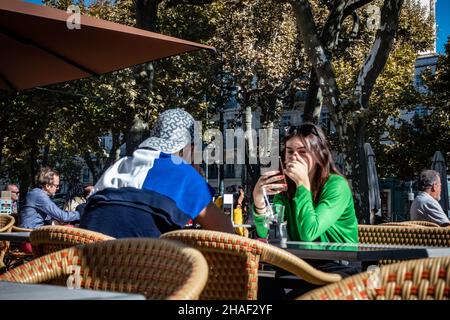 Ein junges Paar, das draußen in einem französischen Straßencafé sitzt Stockfoto