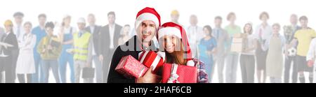 Paar in Weihnachtsmann-Hüte mit Weihnachtsgeschenken und verschiedenen Branchen Herstellung Arbeiter machen Menschen glücklich Konzept Stockfoto