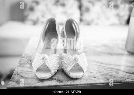 Eine Nahaufnahme der Fersen der Braut auf dem Marmortisch - Hochzeitsvorbereitung Stockfoto