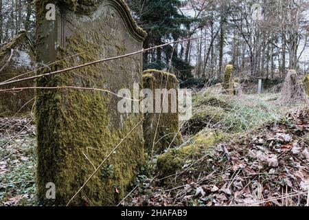 Alte moosige Gräber auf einem verlassenen Friedhof Stockfoto