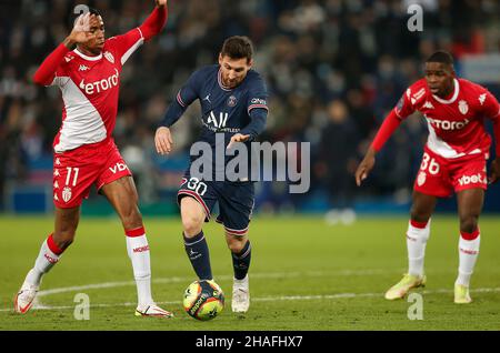 Paris, Frankreich. 12th Dez 2021. Lionel Messi (C) von Paris Saint-Germain steht mit Jean Lucas De Souza Oliveira (L) von Monaco während des Ligue 1-Spiels zwischen Paris Saint-Germain und Monaco am 12. Dezember 2021 in Paris, Frankreich, gegenüber. Quelle: Xinhua/Alamy Live News Stockfoto