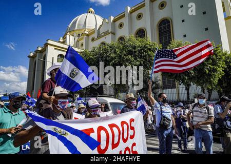 San Salvador, El Salvador. 12th Dez 2021. Ein Protestler schwenkt während des Protestes die Flagge der Vereinigten Staaten und ein anderer die Flagge von El Salvador. Demonstranten gingen auf die Straße, um gegen die Regierung von Nayib Bukele und seine Politik zu protestieren. Kürzlich beschuldigte die US-Regierung Biden die salvadorianischen Regierungsbeamten der Korruption und eines geheimen Waffenstillstands mit organisiertem Verbrechen wie MS-13 und Barrio 18, die Mordaufzeichnungen zu senken. Kredit: SOPA Images Limited/Alamy Live Nachrichten Stockfoto