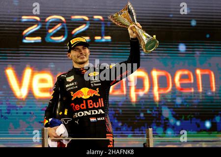 Abu Dhabi. 12th Dez 2021. Der niederländische Red Bull-Pilot Max Verstappen feiert mit der Trophäe nach dem Gewinn des Formel 1 Abu Dhabi Grand Prix in Abu Dhabi, den Vereinigten Arabischen Emiraten, am 12. Dezember 2021. Der niederländische Red Bull-Fahrer Max Verstappen hat den Weltmeister von 2021 gewonnen. Quelle: Xinhua/Alamy Live News Stockfoto