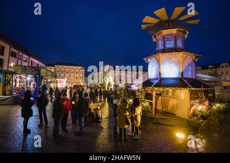 Meiningen, Deutschland. 12th Dez 2021. Die Menschen stehen um einen Glühweinstand, der als Weihnachtspyramide auf dem Markt umgebaut wurde. Nachdem der MEININGER Weihnachtszauber wegen Korona erneut abgesagt wurde, bildet die MEININGER Straßenweihnacht mit weit und breit über den Markt verteilten Hütten mit weihnachtlichen Angeboten einen regelkonformen Ersatz. Quelle: Michael Reichel/dpa/Alamy Live News Stockfoto