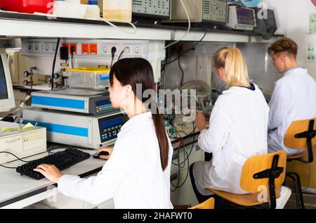 Multirassisches Team von Studenten, die Experimente an Laborgeräten in einem modernen universitären Forschungslabor durchführen Stockfoto