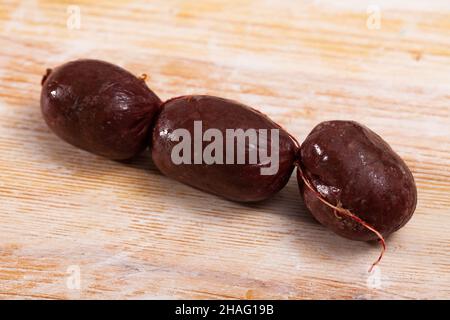Rohe Morcilla im spanischen Stil (Blutwurst mit Reis) auf Holztisch. Stockfoto
