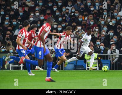 Madrid, Spanien. 12th Dez 2021. Der Real Madrid's Vinicius Jr. (R) tritt während eines Fußballspiels der ersten spanischen Liga zwischen Real Madrid und Atletico de Madrid am 12. Dezember 2021 in Madrid, Spanien, an. Kredit: Gustavo Valiente/Xinhua/Alamy Live Nachrichten Stockfoto