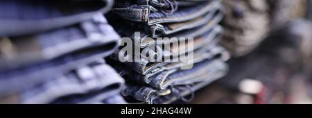 Stapel von blauen Jeans in verschiedenen Schattierungen im Geschäft Nahaufnahme Stockfoto